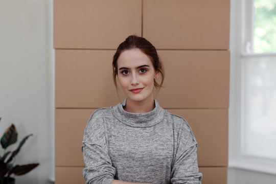 Woman with cardboard boxes in background