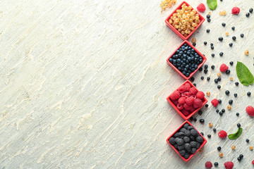 Bowls with various ripe berries on wooden background, top view