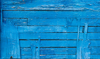 Texture exfoliating cracked blue paint. Vintage wooden background with horizontal boards, with blue paint.