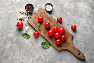 Wooden board with fresh ripe cherry tomatoes on table