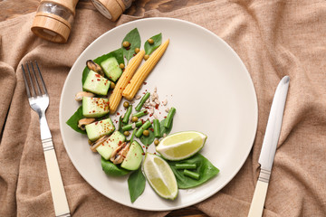 Plate with mussels and vegetables on table