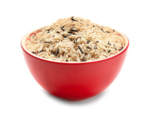 Bowl with unpolished rice on white background