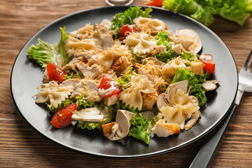 Tasty Caesar salad with pasta on plate