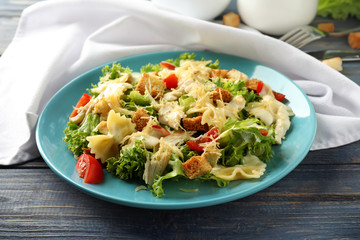 Tasty Caesar salad with pasta on plate