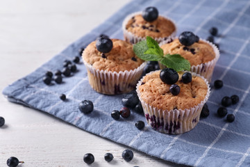 Tasty blueberry muffins on white wooden background