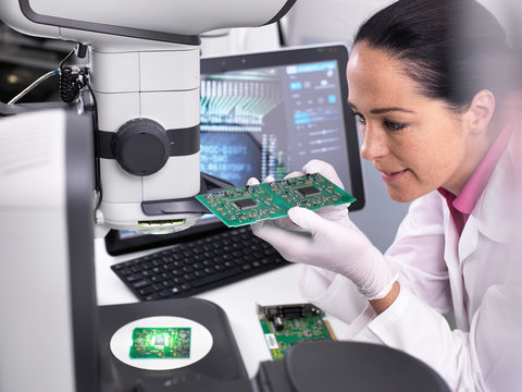 Engineer using 3D servo microscope to view dimensional accuracy of manufactured PCB assembly