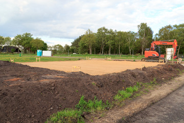 Construction site for one family house filled with sand and digger in building area after earthworks, Germany © johannes86