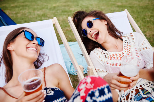 Friends sitting in deck chairs in music festival