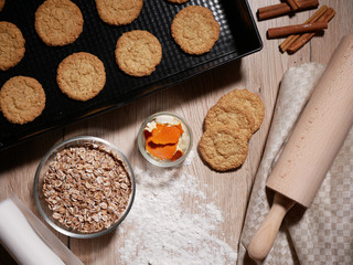 Fresh baked cookies on baking tray. Dough roll and scattered flour. Flat lay.