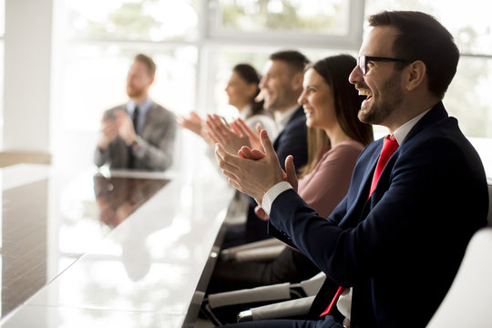 Businesspeople applauding while in a meeting at office