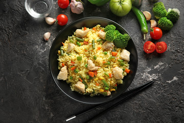 Tasty boiled rice with meat and vegetables in bowl on grunge table