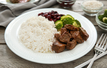 Tasty boiled rice with meat and vegetables on plate