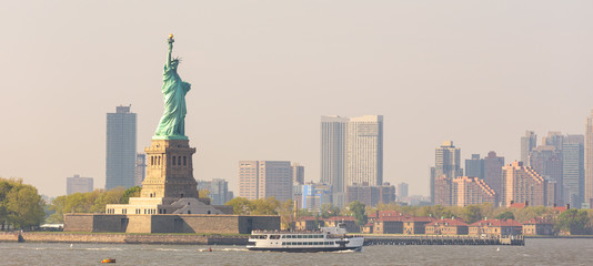 Statue of Liberty with Liberty State Park and Jersey City skyscrapers in background, USA.