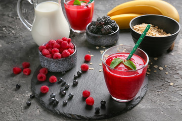 Glass with tasty berry smoothie on slate plate