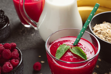 Glass with tasty raspberry smoothie and products on table