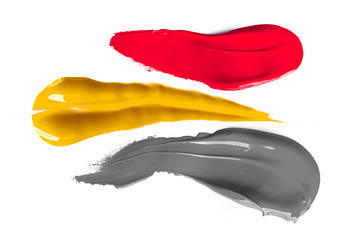 Real liquid color paint stamps. Textured surface isolated on white background. Shiny light glossy reflections. Minimalistic flat lay picture. Red, yellow and grey shades