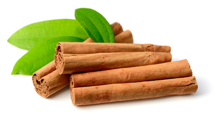 cinnamon sticks with fresh leaves isolated on the white background - obrazy, fototapety, plakaty