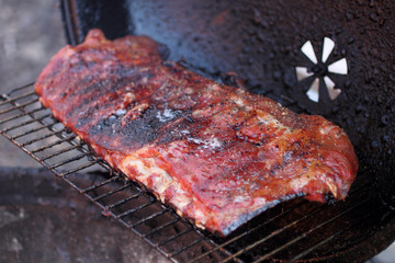 Rack of dry rub pork ribs on the BBQ grill.