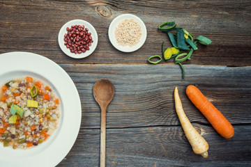 Vegetable Soup with Lentils and Raw Ingredients on Wooden Background