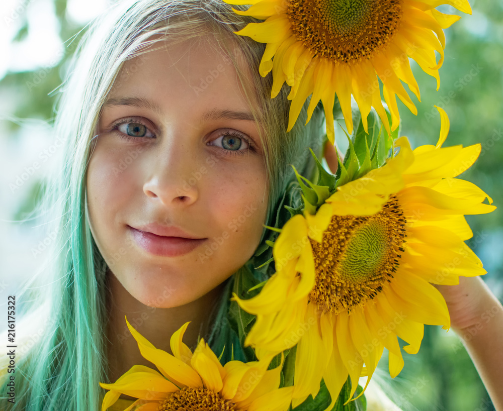 Wall mural portrait of a teenage girl with green hair with sunflowers