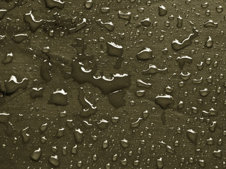 water drops on martini olive colored metallic surface