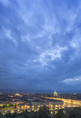 Fototapeta na wymiar night sky with light clouds above night Turin in Italy