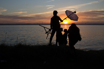 group of photographers at work on the sunset near the lake