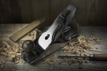 Carpenter tabletop with old hand plane. wood shavings, ruler and carving chisel. Traditional...