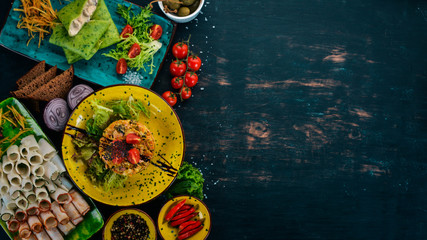 Salad with bacon, mushrooms and fresh vegetables. On a wooden table. Top view. Copy space.
