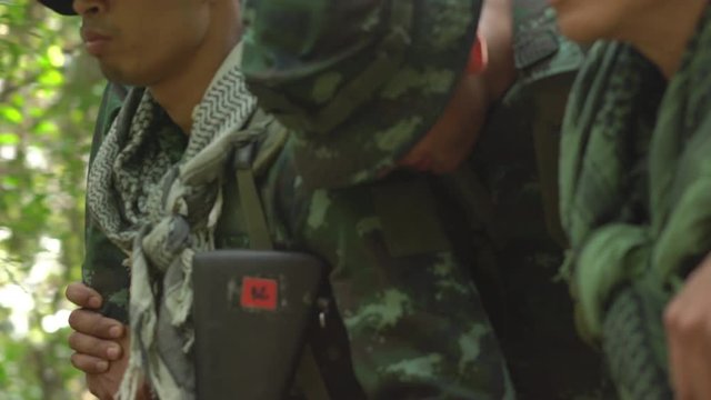 Soldier holding gun weapon and waring armor uniform with smoke. Soldiers are taking the wounded man out of the jungle.