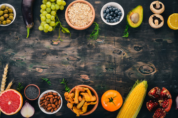 Food. Vegetables, fruits, nuts and berries. Vitamins. On an old wooden table. Top view. Free space for text.