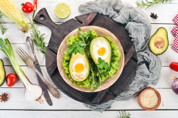 Baked avocado with egg. Healthy food. On a wooden background. Top view. Copy space.