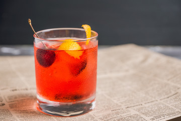 Old fashioned cocktail with cherry and orange peel. Selective focus.