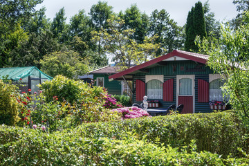 Garden shed and green house surrounded by a beautiful decorative garden