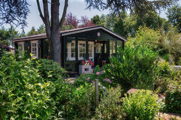 Fototapeta na wymiar Garden shed ssurrounded by a beautiful decorative garden