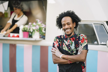 Portrait of a smiling food vendor with a food truk