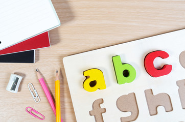 Close up of alphabet board game and basic equipment for elementary student. Wooden ABC alphabet game concept.
