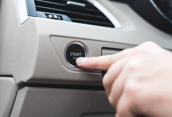 Car start stop system with finger pressing the button, horizontal image