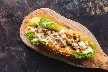 Long bread with mayonnaise on rustic background 