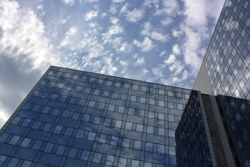 Fototapeta na wymiar Great Building from glass reflecting the blue cloudy sky in numerous windows