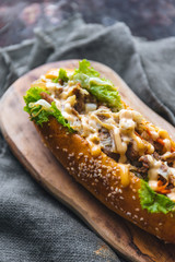 Long bread with mayonnaise on rustic background 