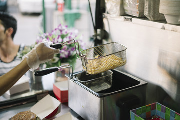 Smiling food vendor hands food to waiting customer