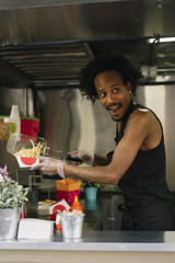 Smiling food vendor hands food to waiting customer