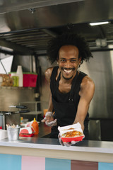 Fototapeta na wymiar Smiling food vendor hands food to waiting customer