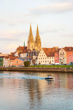 Regensburg city view, Germany. People enjoy beauty on Danube river shore, Regensburg Cathedral and Stone Bridge on background