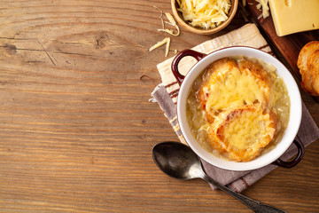 French onion soup with croutons and cheese on rustic wooden table