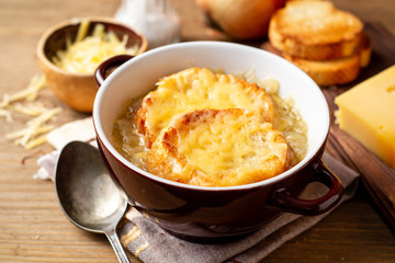 French onion soup with croutons and cheese on rustic wooden table