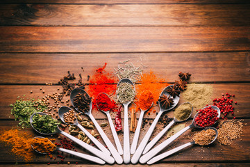 Top view of wooden table full of spices in spoons