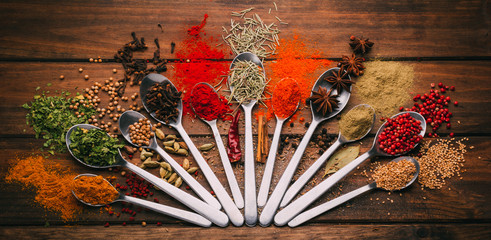 Top view of wooden table full of spices in spoons