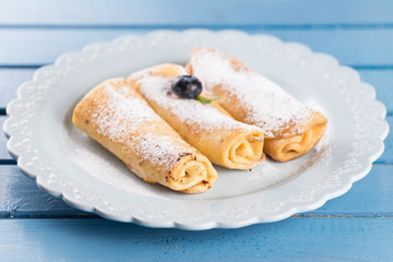 Three homemade rolled pancakes with blueberry